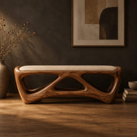 Cushioned bench with an open lattice wood base in a dark studio against a charcoal plaster wall