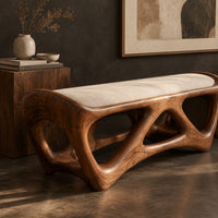 Corner detail of cushioned bench with an open lattice wood base beside wood, brass and linen samples