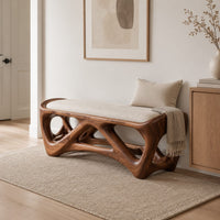 Cushioned bench with an open lattice wood base in a Scandinavian entryway with white walls