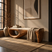 Cushioned bench with a sweeping sculpted body and an oval cutout in an industrial loft entryway with exposed brick