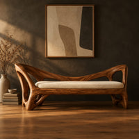 Bench with a cream seat cushion and a sculpted frame full of open cutouts in a dark studio against a charcoal plaster wall