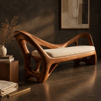 Corner detail of bench with a cream seat cushion and a sculpted frame full of open cutouts beside wood, brass and linen samples