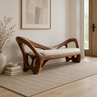 Bench with a cream seat cushion and a sculpted frame full of open cutouts in a Scandinavian entryway with white walls