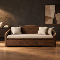 Daybed style sofa with an arched back and a three panel wood front in a dark studio against a charcoal plaster wall