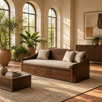 Daybed style sofa with an arched back and a three panel wood front in a bright living room with arched windows and plants