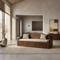 Daybed style sofa with an arched back and a three panel wood front in a bright open plan living room