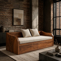 Daybed style sofa with swept wood sides, paneled base and a long seat pad in an industrial loft living room with exposed brick
