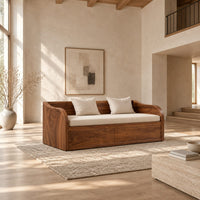 Daybed style sofa with swept wood sides, paneled base and a long seat pad in a bright open plan living room