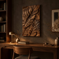 Tall wooden wall art panel with overlapping carved leaf relief above a desk in a dark study corner