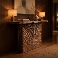 Wooden console table with a live edge top and a deeply carved front in an evening entryway with walnut wall paneling