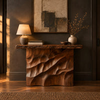 Console table with deep diagonal ripple carving on a solid base in a dark entryway at golden hour
