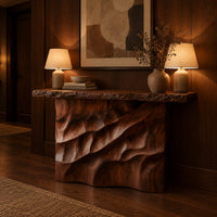 Console table with deep diagonal ripple carving on a solid base in an evening entryway with walnut wall paneling