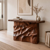 Console table with deep diagonal ripple carving on a solid base in a Scandinavian entryway with white walls