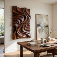 Tall wooden wall panel with deep carved swirls beside a dining table in natural light
