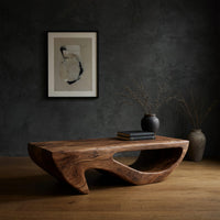 Dark coffee table with a deep U shaped open shelf in a dark studio against a charcoal wall