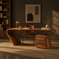 Desk with a top that flows into a slanted leg and drawer pedestal in a dark home office at golden hour