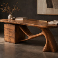 Corner detail of wooden desk with a swooping single leg and a stacked drawer block beside wood, brass and linen samples