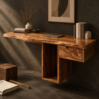 Corner detail of wooden desk with a thick slab top and a hollow column support beside wood, brass and linen samples