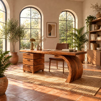 Wood desk with three stacked drawers and one sweeping curved leg in a bright home office with arched windows and plants