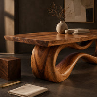 Corner detail of rectangular dining table on a looping ribbon pedestal base beside wood, brass and linen samples