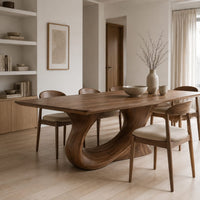 Dining table on a single sweeping pedestal with an oval opening in a Scandinavian dining room with white walls