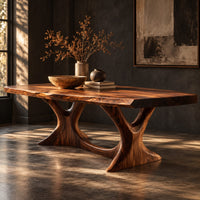Corner detail of dining table with two branching legs and a wavy edged top beside wood, brass and linen samples
