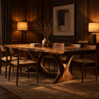Dining table with two branching legs and a wavy edged top in an evening dining room with walnut wall paneling