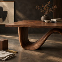 Corner detail of dining table on a continuous double wave base with a smooth plank top beside wood, brass and linen samples