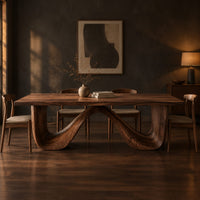 Dining table on a continuous double wave base with a smooth plank top in a dark dining room at golden hour