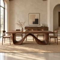Dining table on a continuous double wave base with a smooth plank top in a bright open plan dining room
