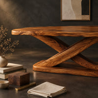 Corner detail of rectangular dining table with a thick plank top on a sculpted loop base beside wood, brass and linen samples
