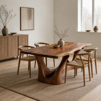 Dining table with a flared wavy top and a carved arch pedestal in a Scandinavian dining room with white walls