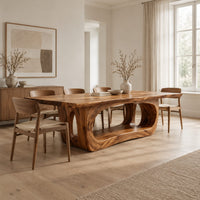 Rectangular dining table with a thick slab top on a hollowed oval base in a Scandinavian dining room with white walls