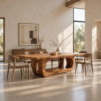 Rectangular dining table with a thick slab top on a hollowed oval base in a bright open plan dining room