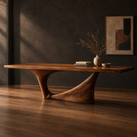 Long dining table on a single swept pedestal with an open arch, three-quarter view showing the grain