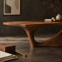 Corner detail of long dining table on a single swept pedestal with an open arch beside wood, brass and linen samples
