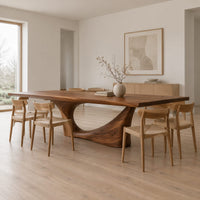 Long dining table on a single swept pedestal with an open arch in a Scandinavian dining room with white walls