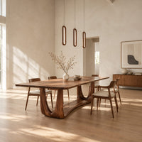 Dining table with a smooth top on an open u frame base in a bright open plan dining room