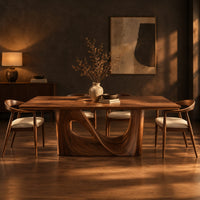 Dining table with a smooth rectangular top and a wave sculpted base in a dark dining room at golden hour