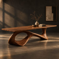 Long dining table on a sweeping ribbon base with one large oval opening, three-quarter view showing the grain