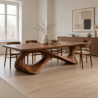 Long dining table on a sweeping ribbon base with one large oval opening in a Scandinavian dining room with white walls