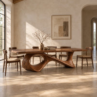 Long dining table on a sweeping ribbon base with one large oval opening in a bright open plan dining room