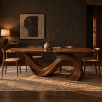 Dining table with a single sweeping wave base under a long slab top in a dark dining room at golden hour