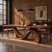 Dining table with a single sweeping wave base under a long slab top in an industrial loft dining room with exposed brick