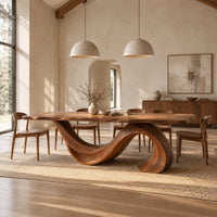 Dining table with a single sweeping wave base under a long slab top in a bright open plan dining room