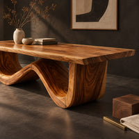 Corner detail of dining table with a thick plank top on one sculpted wave base beside wood, brass and linen samples
