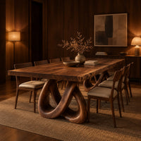 Dining table with two knotted loop pedestals and a thick slab top in an evening dining room with walnut wall paneling