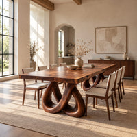 Dining table with two knotted loop pedestals and a thick slab top in a bright open plan dining room