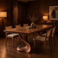 Dining table with two sculpted pedestal legs and a thick flat top in an evening dining room with walnut wall paneling