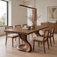 Dining table with two sculpted pedestal legs and a thick flat top in a Scandinavian dining room with white walls